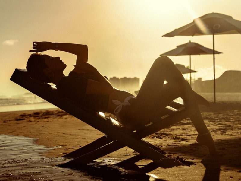 a woman lying on a chair on a beach